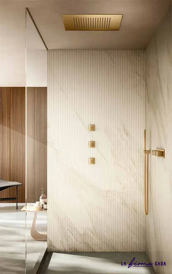 Pale marble shower with brushed gold fittings by Aquaelite in Canada