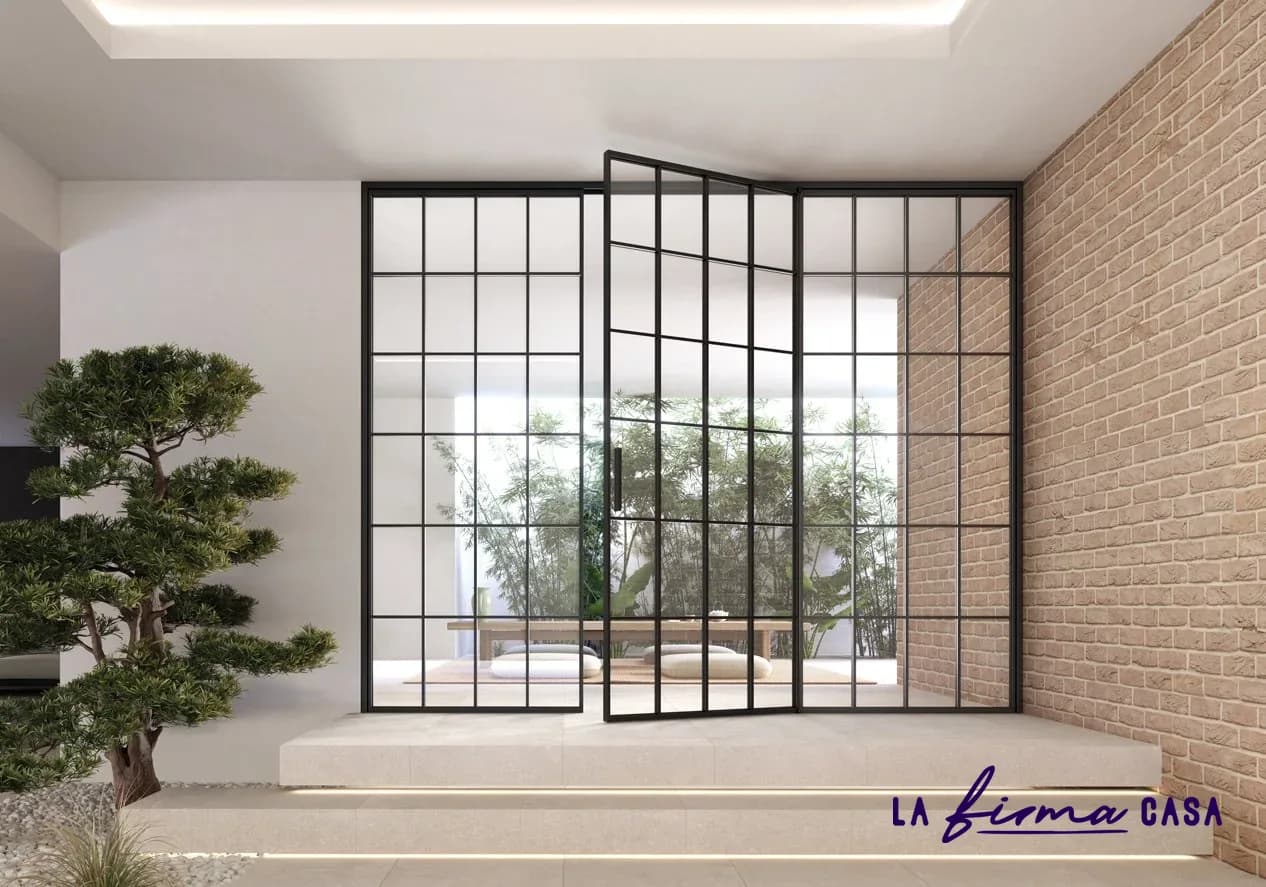 Black grid glazed door on an exposed brick wall by Barausse in Canada