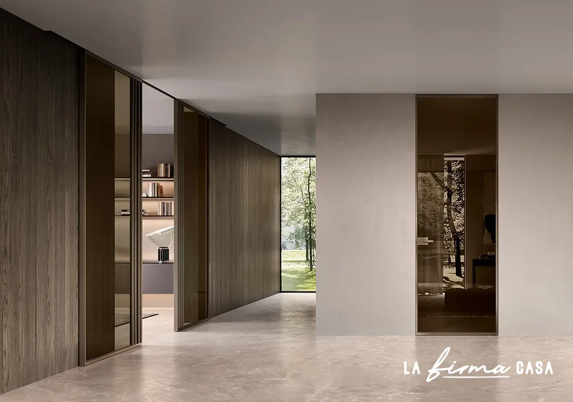 Walnut corridor with a mirrored pivot door by Barausse in Canada