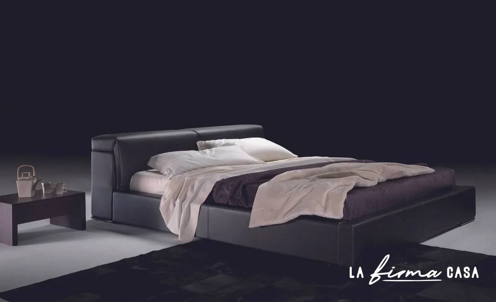 Dark upholstered bed with bedside table by Gyform in Canada