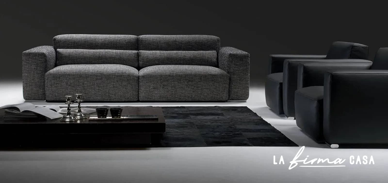 Grey sofa with reclining headrests in a dark room by Gyform in Canada